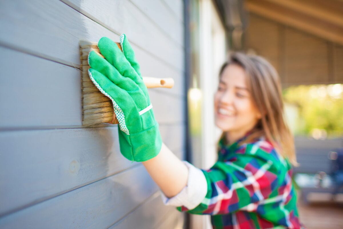 Woman painting outside of her home